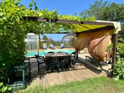 a patio with a table and chairs and a pool at Maison au calme piscine mer au coeur de la nature U Nuciolu in Talasani