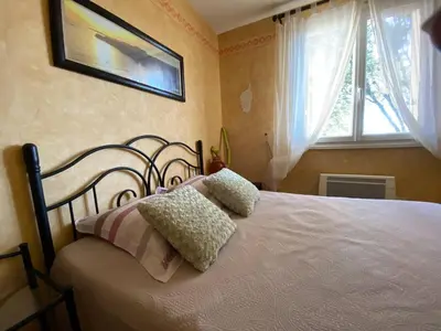 a bedroom with a bed with two pillows on it at Maison au calme piscine mer au coeur de la nature U Nuciolu in Talasani