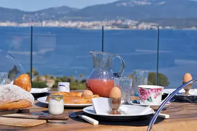 a table with food and eggs and a view of the water at Villa Urbana in Porticcio