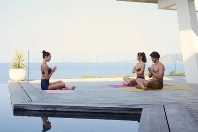 a group of people doing yoga by the water at Villa Urbana in Porticcio