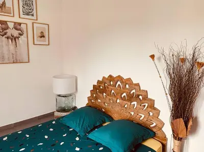a bedroom with a bed with a wooden head board at LA VILLA DE AUDREY MER ET MONTAGNE in Santa-Lucia-di-Moriani