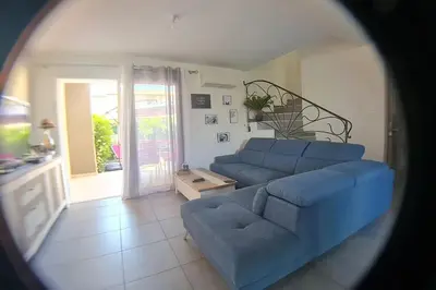 a living room with a blue couch and a table at LA VILLA DE AUDREY MER ET MONTAGNE in Santa-Lucia-di-Moriani