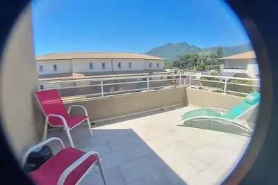 a view of a balcony with chairs on a roof at LA VILLA DE AUDREY MER ET MONTAGNE in Santa-Lucia-di-Moriani