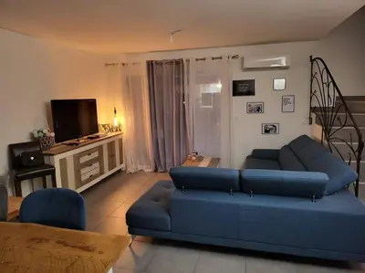 a living room with a blue couch and a television at LA VILLA DE AUDREY MER ET MONTAGNE in Santa-Lucia-di-Moriani