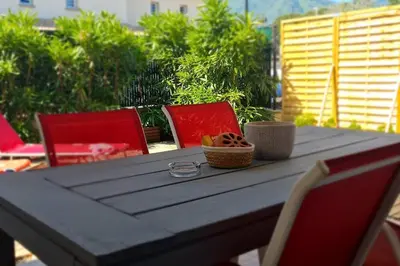 a wooden table with red chairs and a tableasteryasteryasteryasteryasteryasteryastery at LA VILLA DE AUDREY MER ET MONTAGNE in Santa-Lucia-di-Moriani