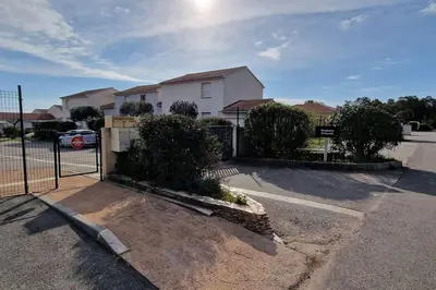 a house with a fence in front of a parking lot at Villa La Casa de Giuseppe in Cervione