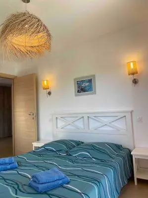 a bedroom with a bed with blue towels on it at Saint-Florent Appartement duplex in Oletta