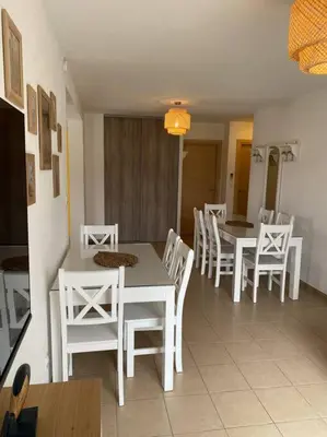 a dining room with white tables and white chairs at Saint-Florent Appartement duplex in Oletta