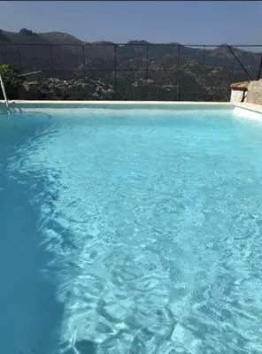 a large pool of blue water with a view at Casa Orsini in Nessa