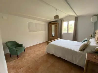 a bedroom with a bed and a green chair at Casa Orsini in Nessa