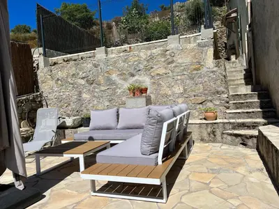 a patio with two chairs and a couch on a stone wall at Casa Orsini in Nessa