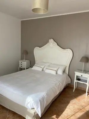 a bedroom with a large white bed with pillows at Casa Orsini in Nessa