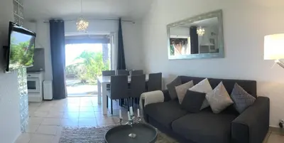 a living room with a couch and a table at Residence Bellavista à Santa Giulia, proche de la plage et vue mer in Porto-Vecchio
