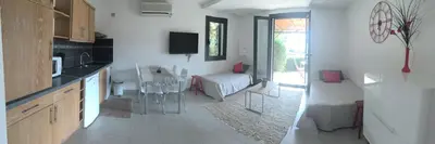 a kitchen with a table and a living room at Residence Bellavista à Santa Giulia, proche de la plage et vue mer in Porto-Vecchio