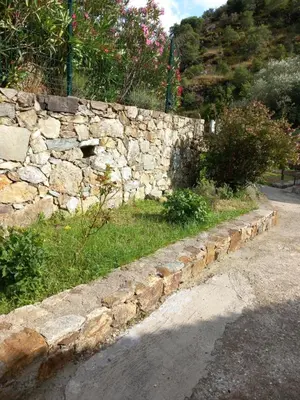 a stone wall on the side of a road at A Guinguetta in Venaco