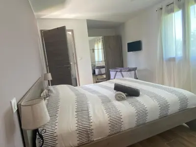 a bedroom with a bed with a black and white comforter at Terra bella Costa Verde T2 classé 3 étoiles in San-Nicolao