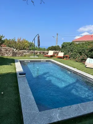 a swimming pool with blue water in a yard at Corse entre mer et montagne in Lavatoggio