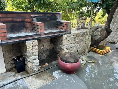 a stone wall with a large red pot and a brickburning at Corse entre mer et montagne in Lavatoggio