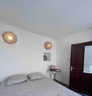 a bedroom with a bed and two lights on the wall at Corse entre mer et montagne in Lavatoggio