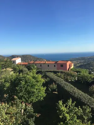 a house on a hill with the ocean in the background at Corse entre mer et montagne in Lavatoggio