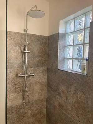 a shower in a bathroom with a window at Petite maison avec terrasse. in Ajaccio