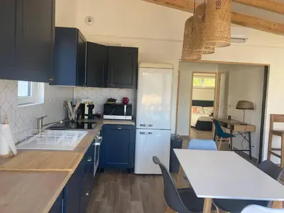 a kitchen with blue cabinets and a white refrigerator at Petite maison avec terrasse. in Ajaccio