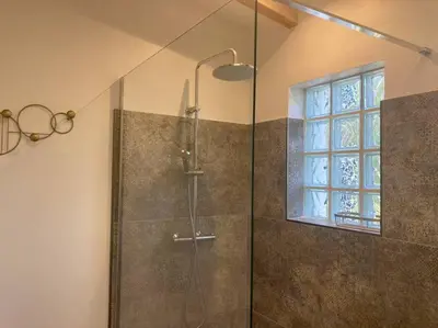 a bathroom with a shower with a glass door at Petite maison avec terrasse. in Ajaccio