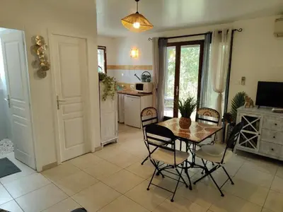 a kitchen and dining room with a table and chairs at Studio 150 m de la plage Agosta in Albitreccia