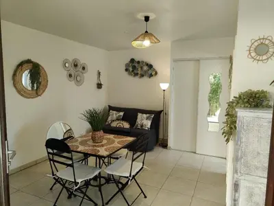 a living room with a table and chairs and a couch at Studio 150 m de la plage Agosta in Albitreccia