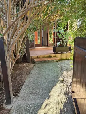 a walkway with a bench and a building at Studio 150 m de la plage Agosta in Albitreccia