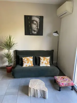 a living room with a green couch and a table at Appartement cosy climatisé dans résidence fermée in Sarrola-Carcopino