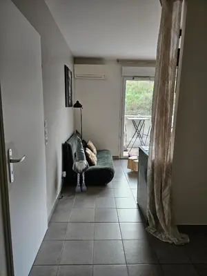 a living room with a couch and a window at Appartement cosy climatisé dans résidence fermée in Sarrola-Carcopino