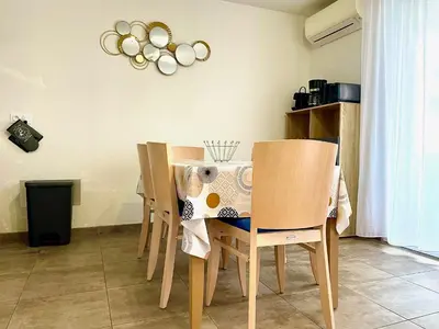 a dining room with a table and chairs at Villa Noelly - Résidence les Hauts de Bonifacio in Bonifacio