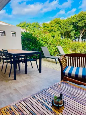 a patio with a table and chairs on a deck at Villa Noelly - Résidence les Hauts de Bonifacio in Bonifacio