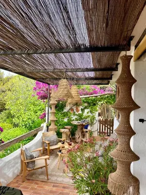 a patio with a pergola and chairs and flowers at Villa LILY BAY baie de Santa Giulia-Porto Vecchio in Porto-Vecchio