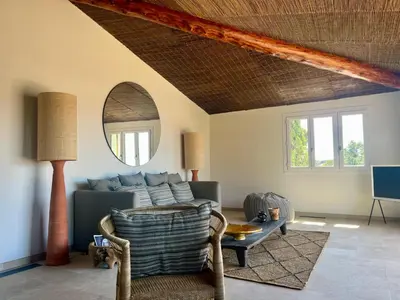 a living room with a couch and a mirror at Villa LILY BAY baie de Santa Giulia-Porto Vecchio in Porto-Vecchio