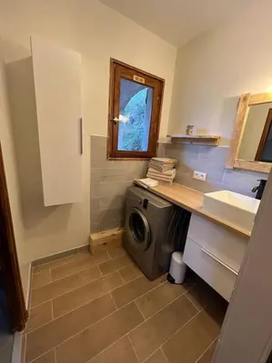 a laundry room with a washing machine and a sink at Appartement 90 m2 proche de Corte in Soveria