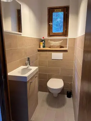 a bathroom with a toilet and a sink and a window at Appartement 90 m2 proche de Corte in Soveria