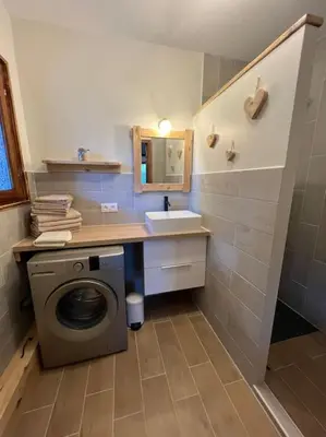 a bathroom with a washing machine and a sink at Appartement 90 m2 proche de Corte in Soveria