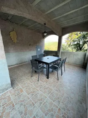 a patio with a table and chairs on a patio at Appartement 90 m2 proche de Corte in Soveria