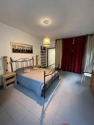 a bedroom with a bed and a red curtain at Appartement 90 m2 proche de Corte in Soveria