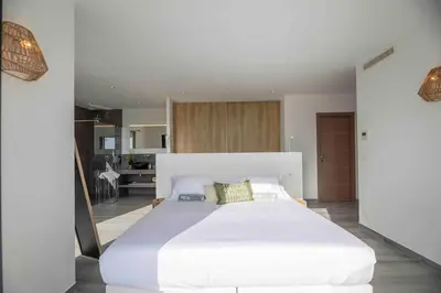a large white bed in a large room at Ivona Vacances - Villa de luxe avec piscine chauffée à Santa-Giulia in Porto-Vecchio