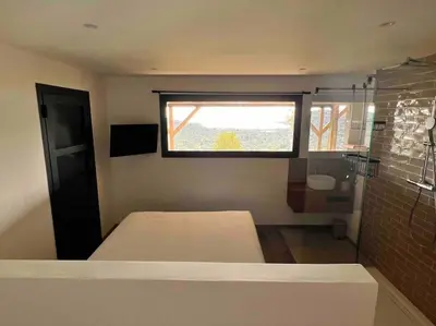 a small bedroom with a bed and a window at Ivona Vacances - Villa de luxe avec piscine chauffée à Santa-Giulia in Porto-Vecchio