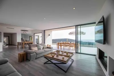 a living room with a couch and a table at Ivona Vacances - Villa de luxe avec piscine chauffée à Santa-Giulia in Porto-Vecchio