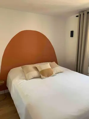 a bedroom with a large white bed with a wooden headboard at Appartement duplex Porticcio avec parking in Porticcio