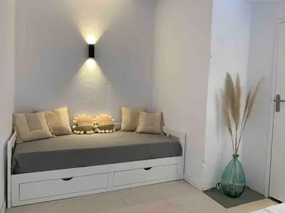 a bedroom with a bed with a light above it at Appartement duplex Porticcio avec parking in Porticcio
