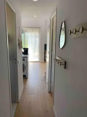 a hallway with a white door and a kitchen at Appartement duplex Porticcio avec parking in Porticcio
