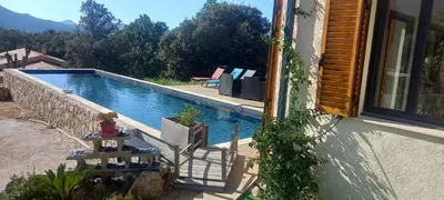 a house with a swimming pool next to a window at Maison neuve Vue imprenable Piscine et spa in Calenzana