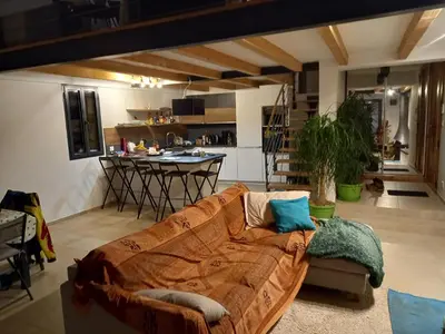 a living room with a couch and a kitchen at Maison neuve Vue imprenable Piscine et spa in Calenzana