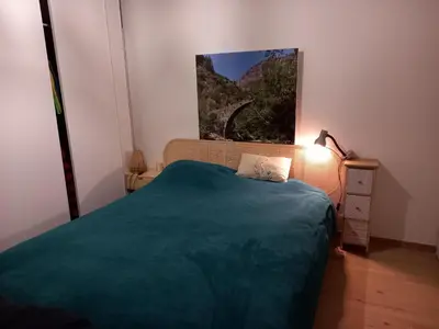 a bedroom with a bed and a painting on the wall at Maison neuve Vue imprenable Piscine et spa in Calenzana